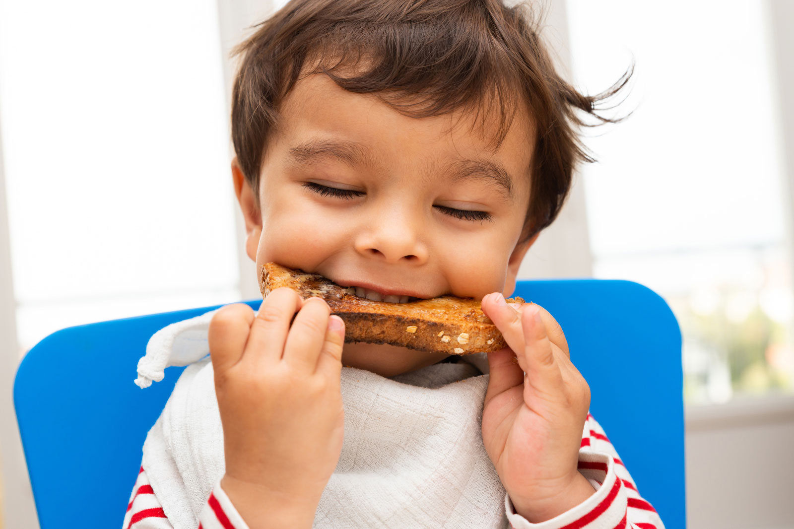 Child who is eating a sandwhich during feeding therapy session with Mestre Behavior